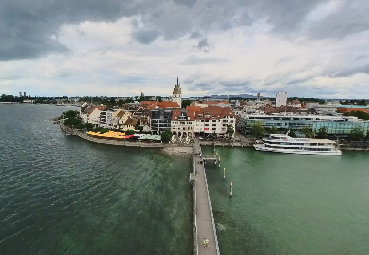 Luftaufnahme der Seepromenade mit Hafen, Ausflugsschiff und Kirchturm.