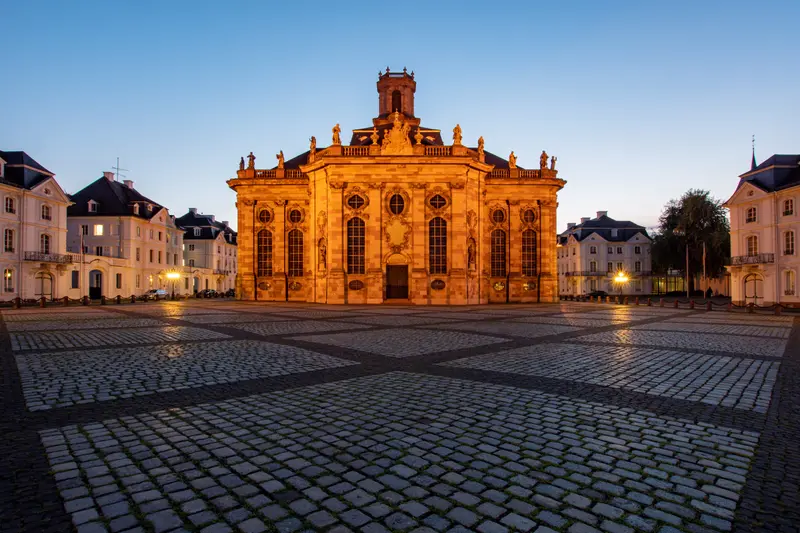 Barocke Kirche am gepflasterten Platz in der blauen Stunde.